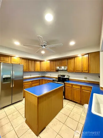 a kitchen with stainless steel appliances granite countertop a sink and a refrigerator