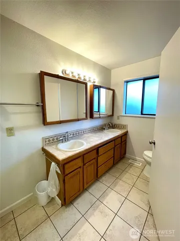a bathroom with a granite countertop sink a toilet and shower