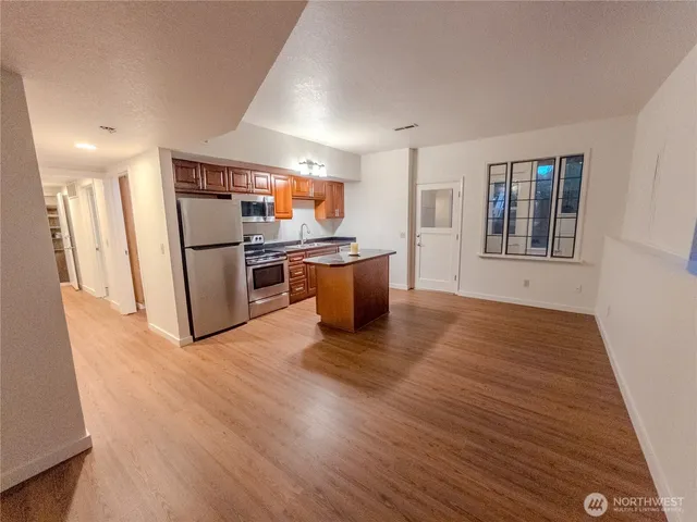 a kitchen with stainless steel appliances granite countertop a refrigerator a stove a sink and a refrigerator