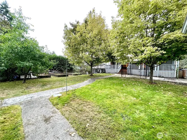 a view of a backyard with table and chairs under an umbrella