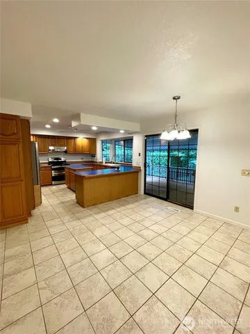 a kitchen with stainless steel appliances kitchen island granite countertop a refrigerator and a stove top oven