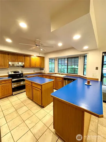 a kitchen with stainless steel appliances kitchen island granite countertop a sink and counter space