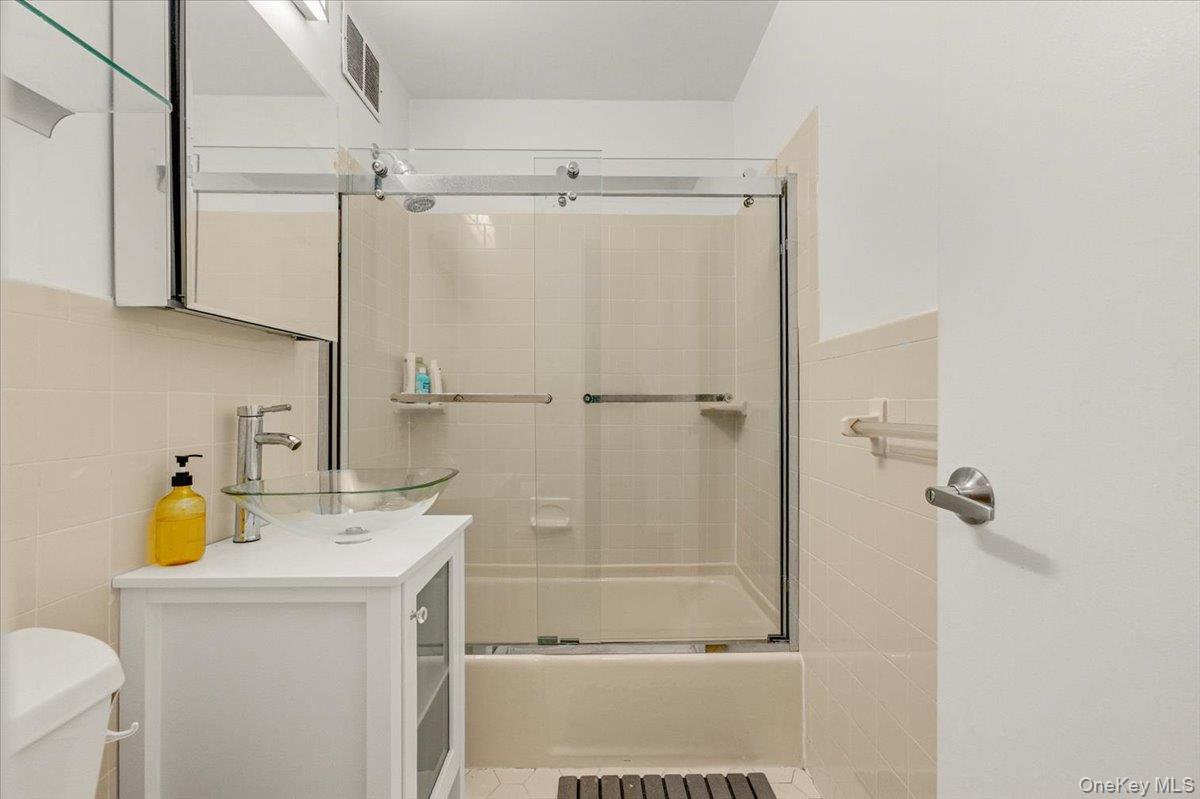 6 Birchwood Court, Unit 5B Mineola, NY 11501 - Photo 11 of 13 a bathroom with a sink a toilet and shower