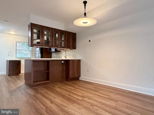 a view of a kitchen with wooden floor and a window