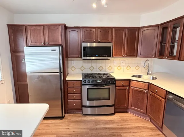 a kitchen with a wooden floor and cabinets