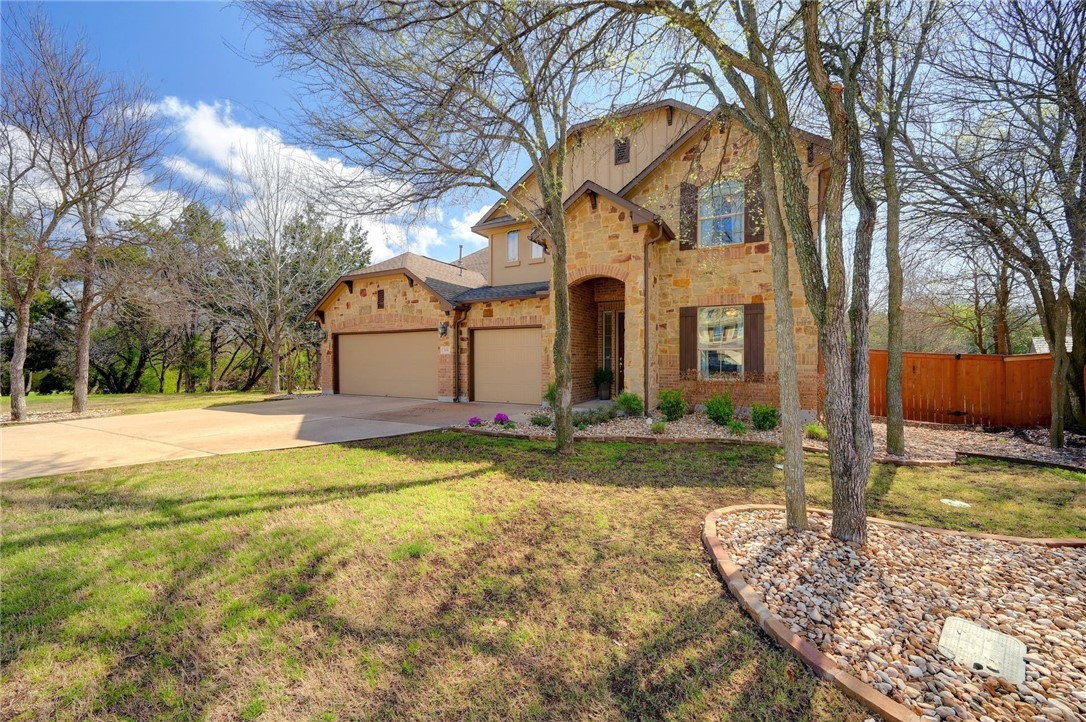 a front view of house with yard and trees in the background
