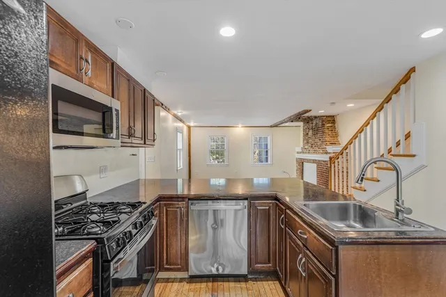a kitchen with stainless steel appliances granite countertop a sink stove and cabinets