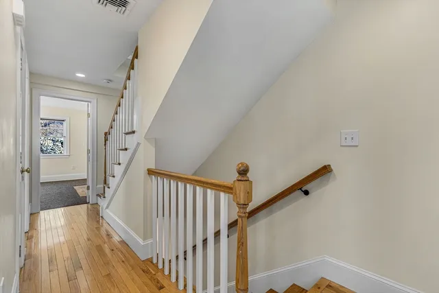 a view of a hallway with wooden floor and entryway