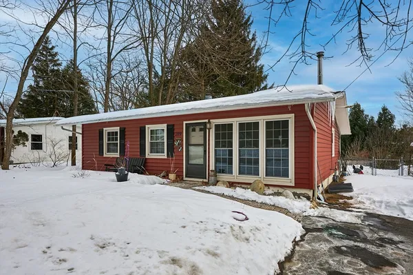 a front view of a house with a yard covered in snow