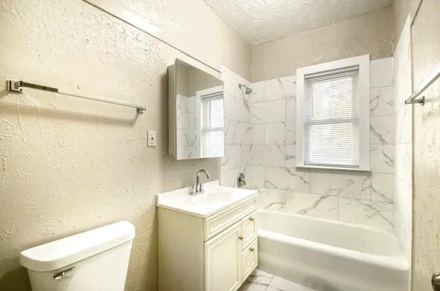 a bathroom with a sink a toilet and bathtub