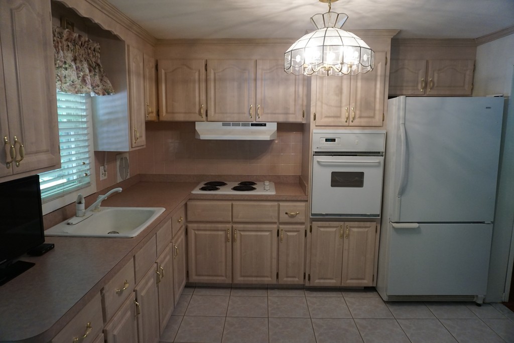 16 Cherry Road Framingham, MA 01701 - Photo 3 of 12 a kitchen with a sink a stove a refrigerator and cabinets
