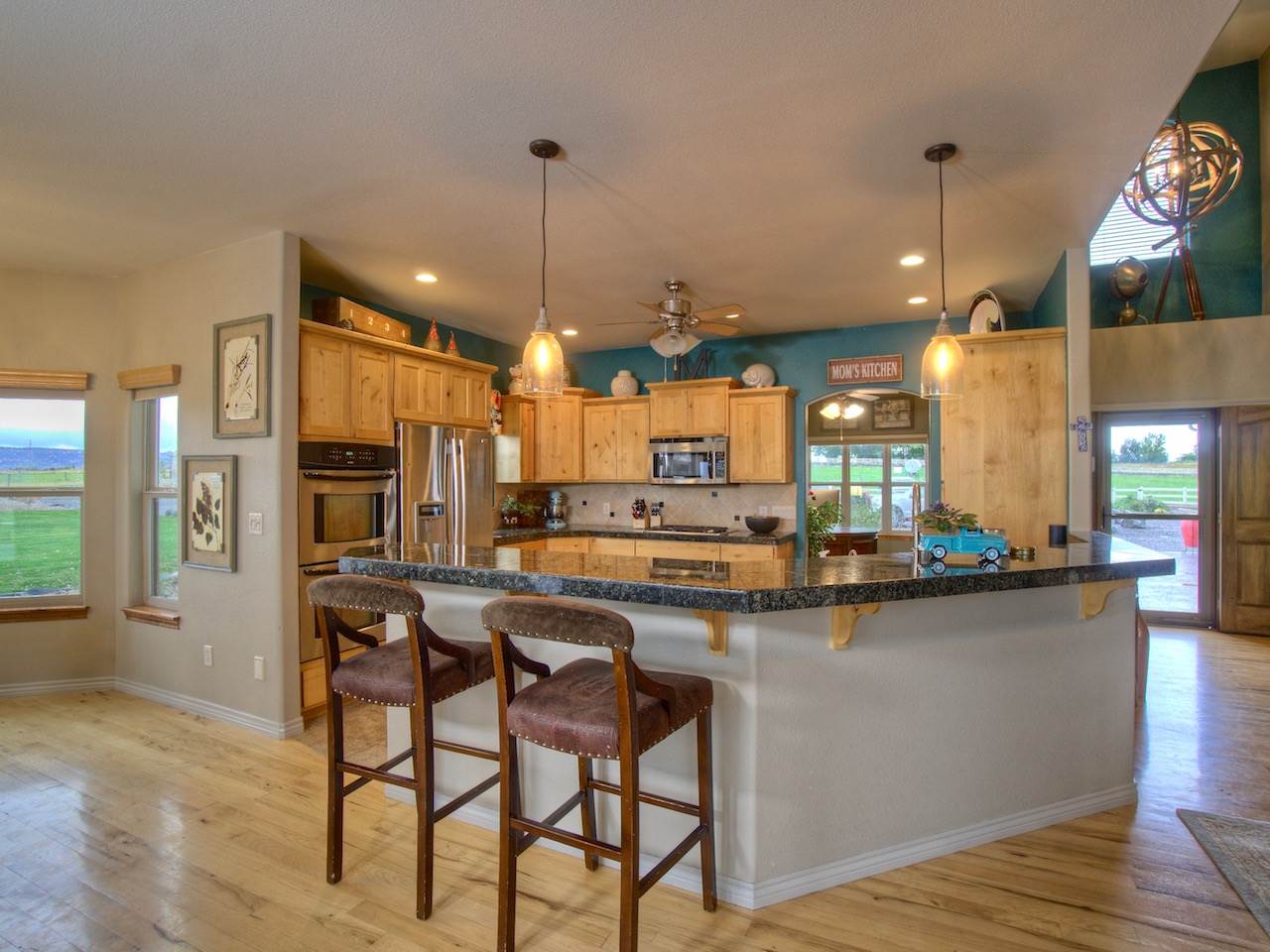 1516 13 Road Loma, CO 81524 - Photo 14 of 32 a kitchen with stainless steel appliances a dining table chairs stove and refrigerator