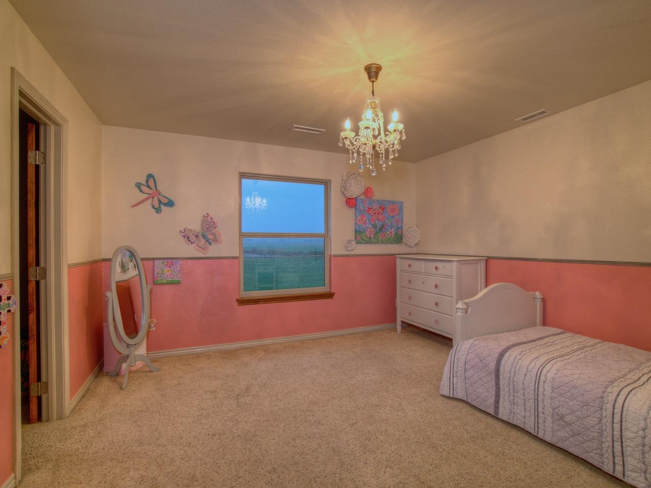 1516 13 Road Loma, CO 81524 - Photo 25 of 32 a spacious bedroom with a bed and a chandelier