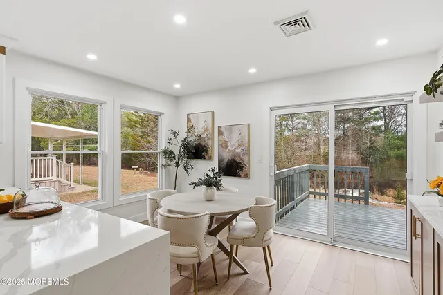 a dining room with furniture a chandelier and wooden floor