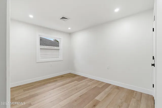 a view of a room with wooden floor and window