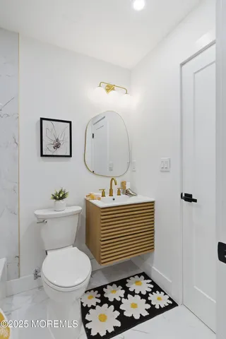 a bathroom with a toilet a sink and mirror