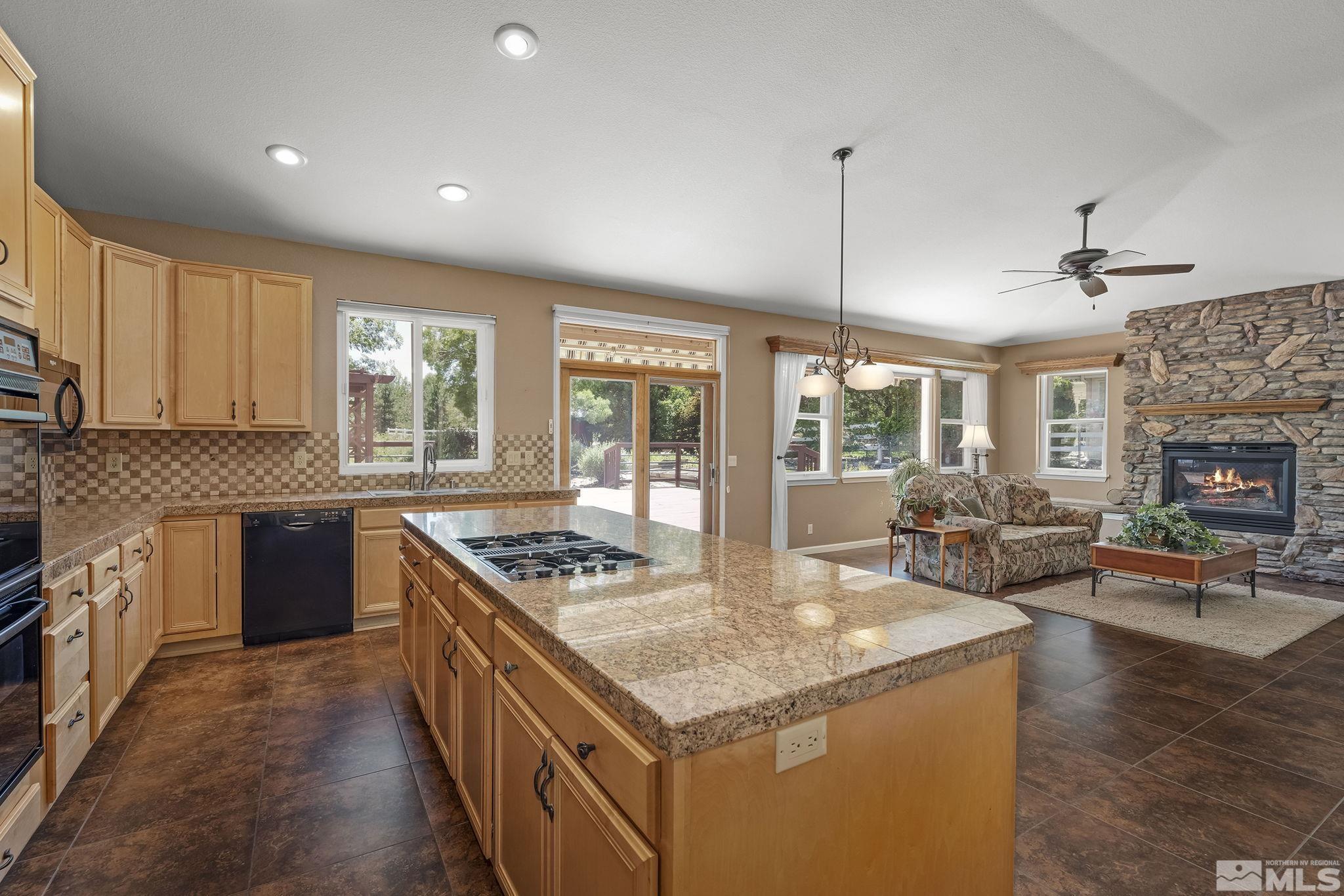 820 Flanders Road Reno, NV 89511 - Photo 11 of 40 a kitchen with stainless steel appliances granite countertop a stove and a view of living room