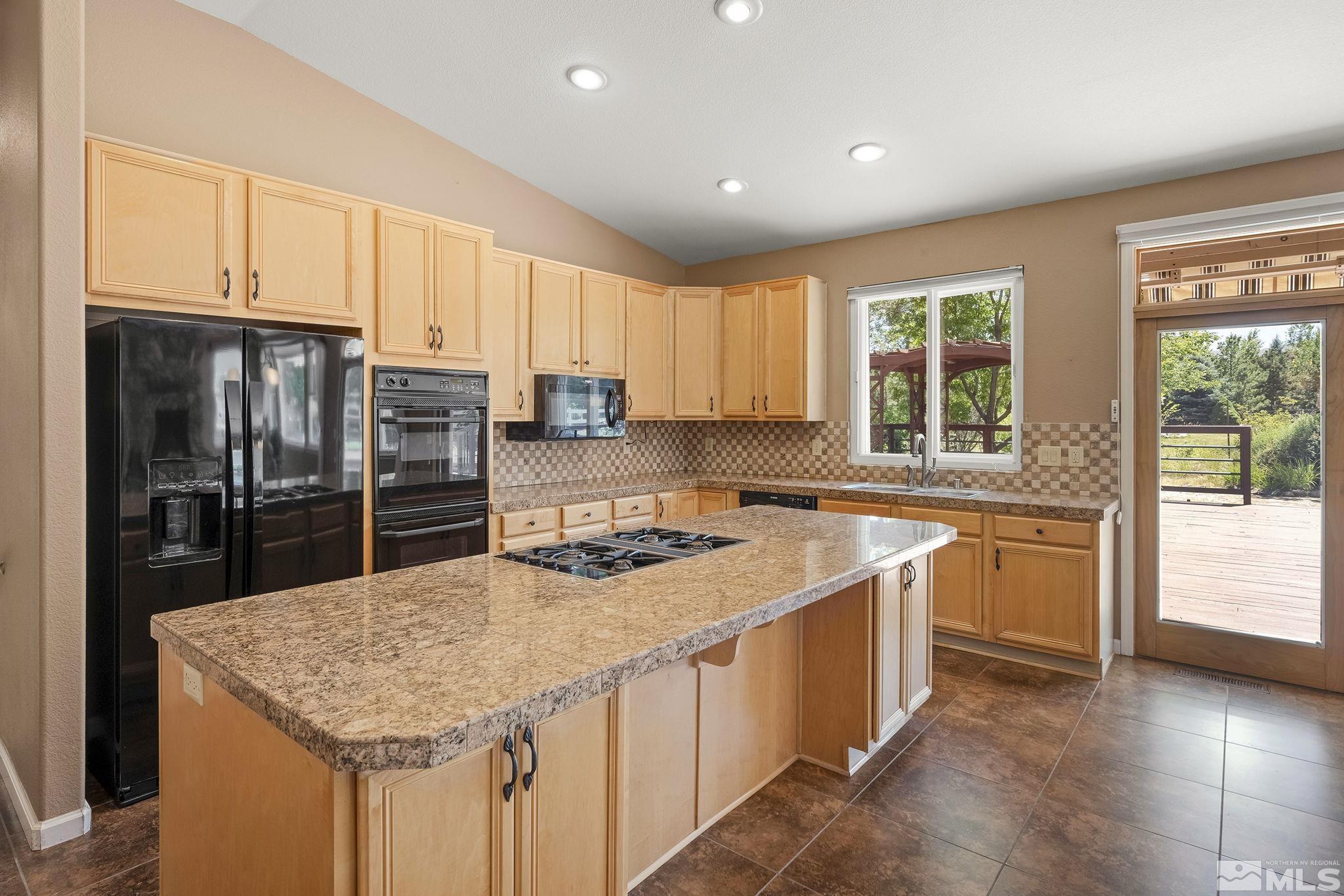 820 Flanders Road Reno, NV 89511 - Photo 12 of 40 a kitchen with stainless steel appliances granite countertop a sink stove and refrigerator
