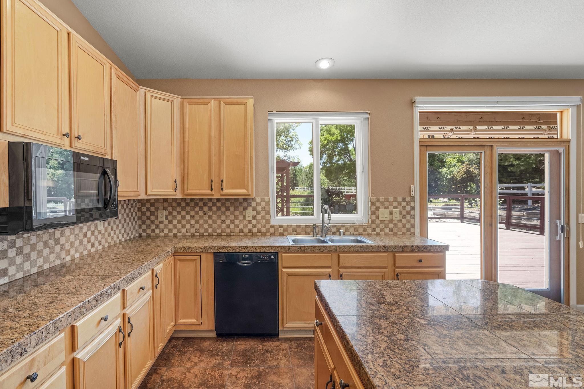 820 Flanders Road Reno, NV 89511 - Photo 13 of 40 a kitchen with stainless steel appliances granite countertop a stove a sink and a microwave