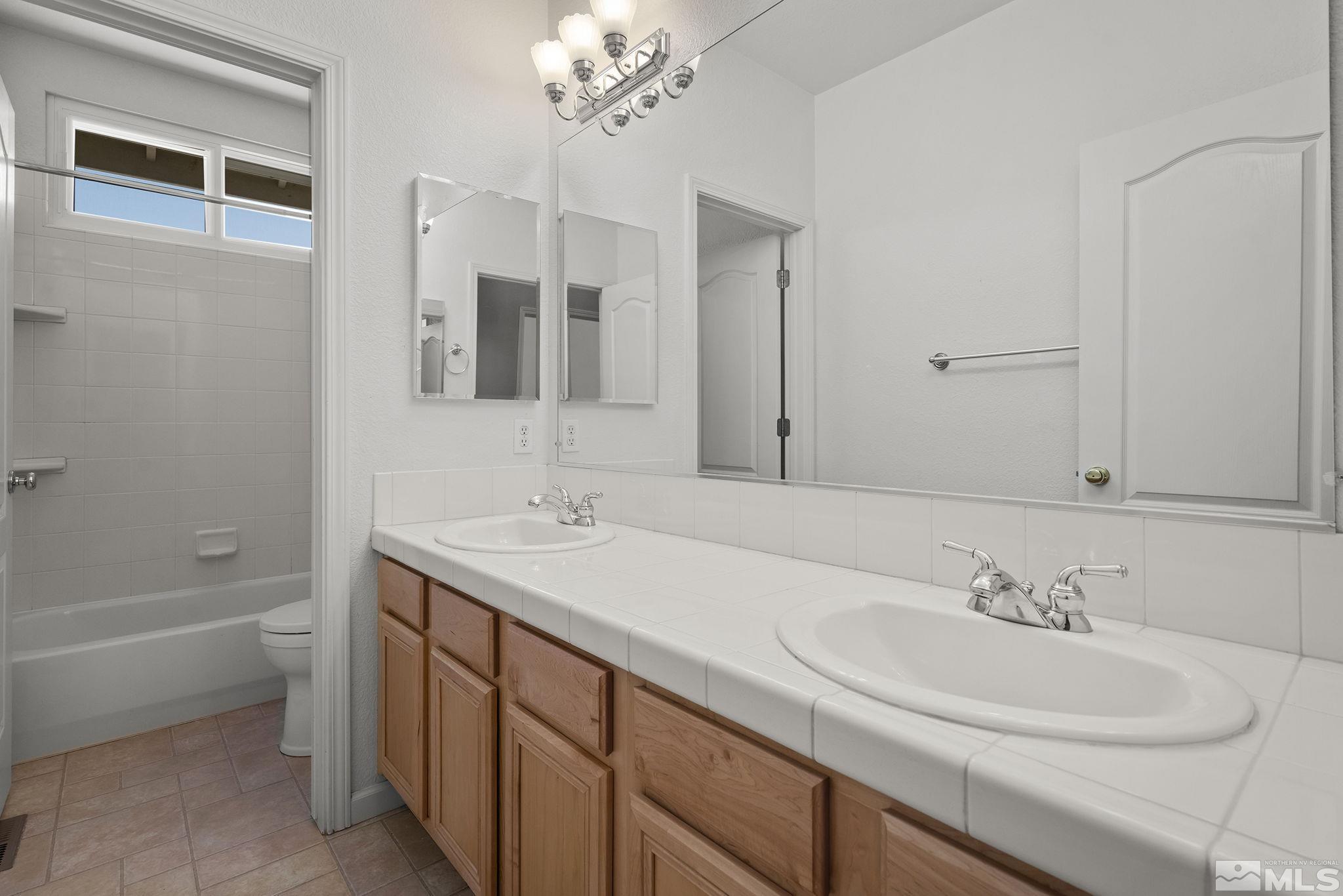 820 Flanders Road Reno, NV 89511 - Photo 29 of 40 a bathroom with a sink double vanity granite tub and a mirror