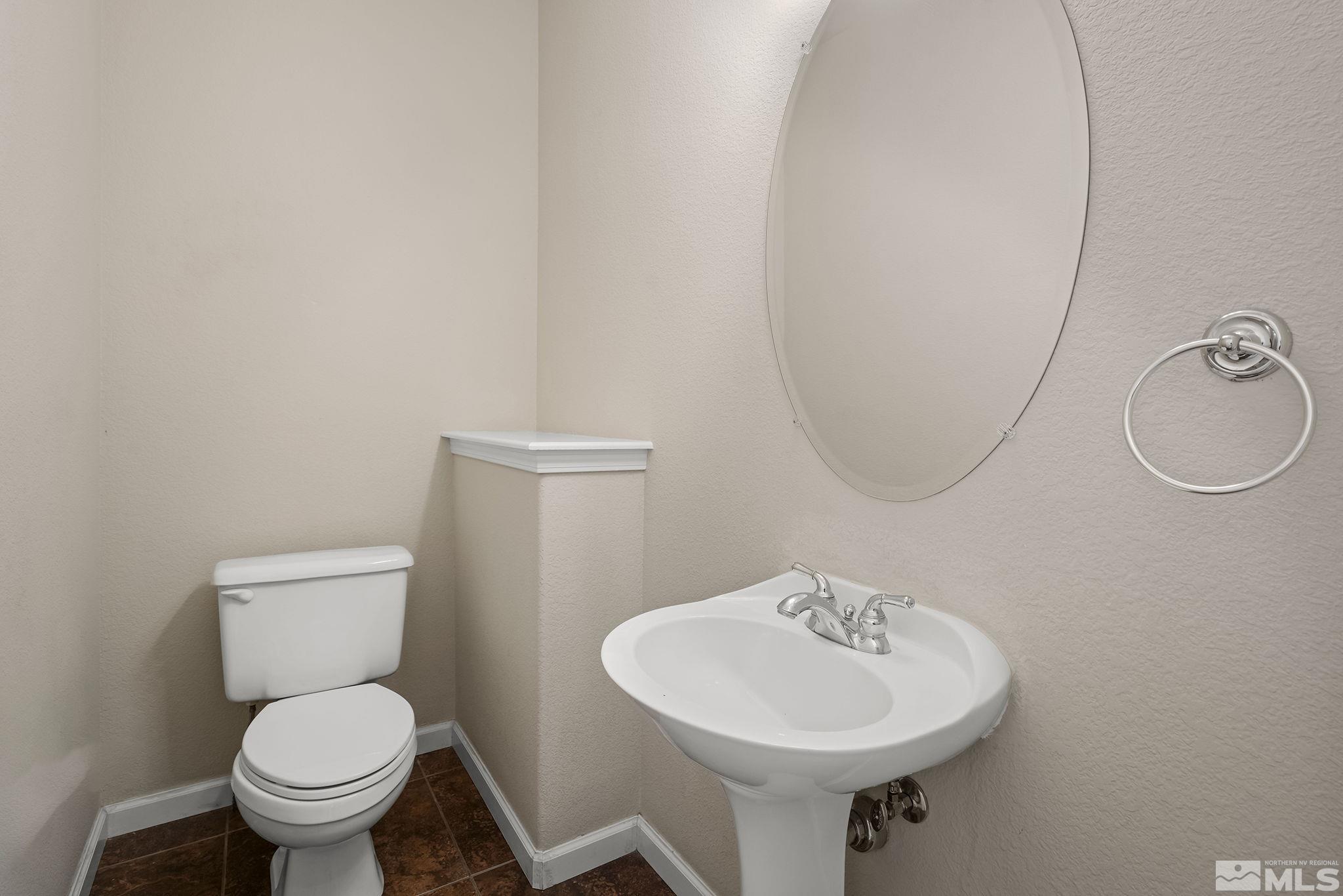 820 Flanders Road Reno, NV 89511 - Photo 30 of 40 a bathroom with a toilet a sink and a mirror