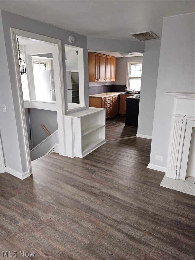 832 Hoover Road Cleveland, OH 44119 - Photo 6 of 10 Kitchen featuring wood finish cabinetry, light countertops, dark wood-style floors, and fridge