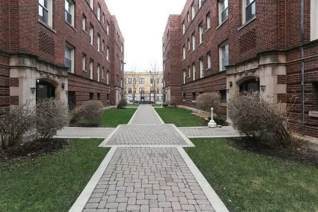 a view of a brick building next to a yard
