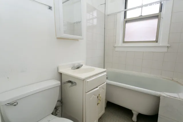 a bathroom with a sink toilet vanity and bathtub