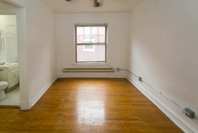 a view of a room with wooden floor and a window