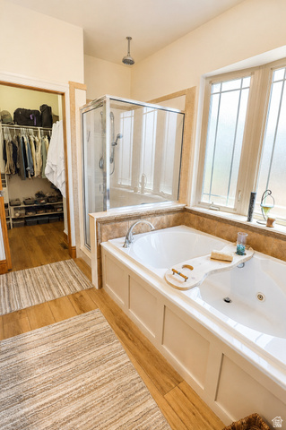 1055 North 1000 East Mapleton, UT 84664 - Photo 14 of 112 Soaking tub with a paneled surround, glass-enclosed shower, wood-finish flooring, and a large window with frosted panes