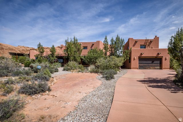 3617 Red Rock Drive Moab, UT 84532 - Photo 2 of 79 View of front facade with stucco siding, driveway, and an attached garage