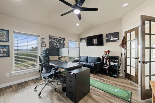 a view of a workspace with furniture and a ceiling fan