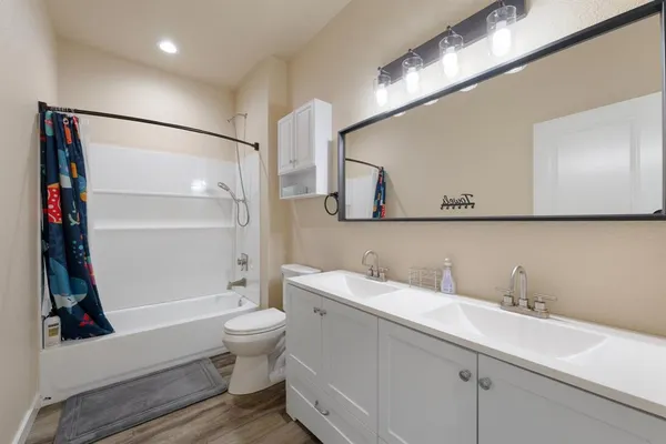 a bathroom with a sink a toilet and a large mirror