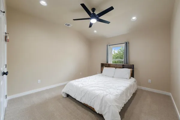 a bed room with a bed and a ceiling fan