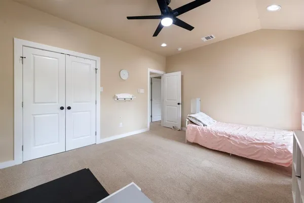 a bed room with a bed and a ceiling fan