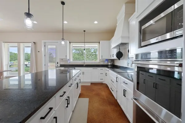 a large kitchen with stainless steel appliances granite countertop a lot of counter space