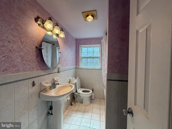 a bathroom with a sink toilet and a mirror