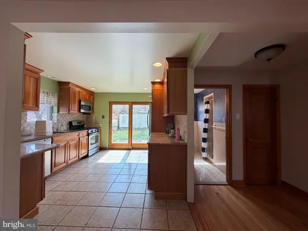 a large kitchen with stainless steel appliances granite countertop a refrigerator and a stove top oven
