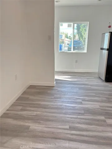 a view of empty room with window and wooden floor