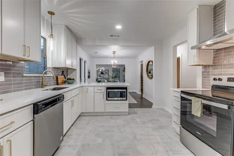 a kitchen with stainless steel appliances a stove sink and cabinets