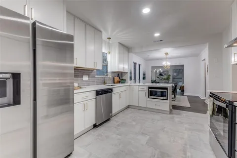 a kitchen with white cabinets and appliances