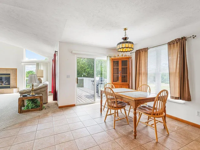 a kitchen with stainless steel appliances granite countertop table chairs sink and window