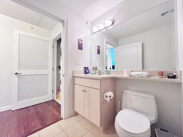 a bathroom with a toilet sink vanity and mirror
