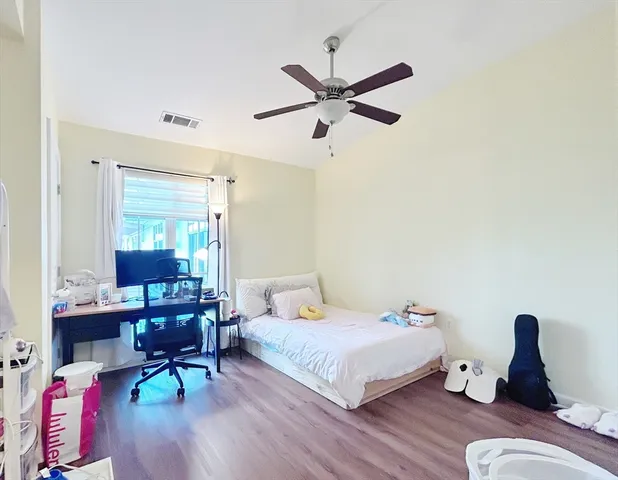a bedroom with a bed and wooden floor