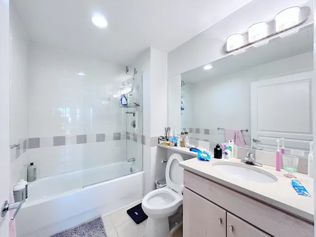 a bathroom with a sink a toilet a mirror a bathtub and shower