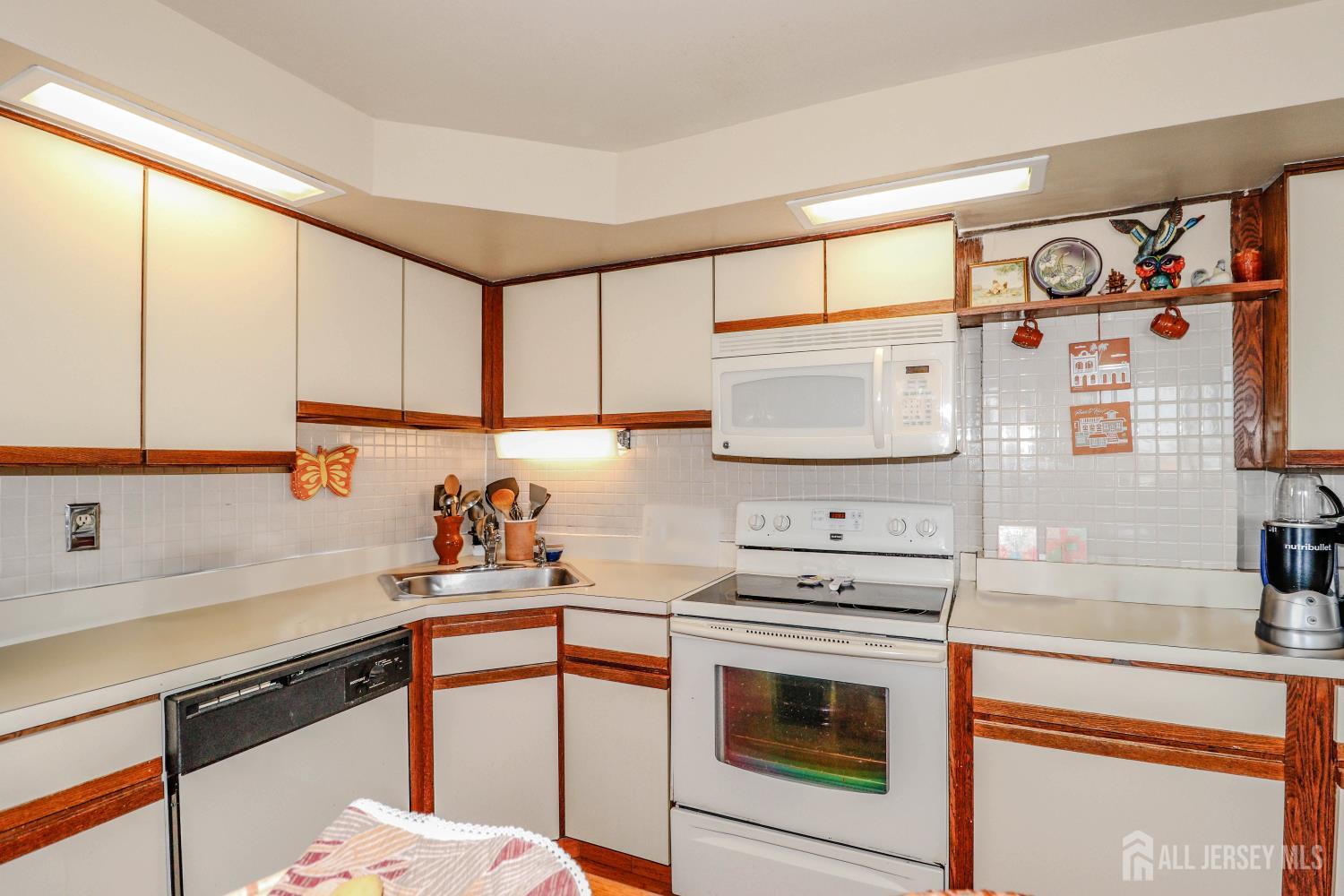 40 Fayette Street, Unit 57 Perth Amboy, NJ 08861 - Photo 9 of 33 a kitchen with stainless steel appliances a sink cabinets and a window