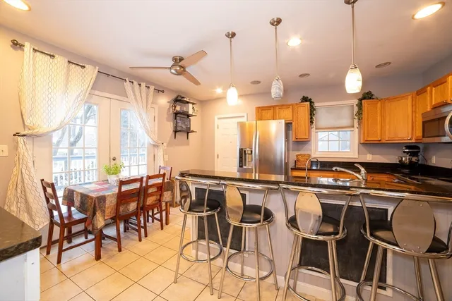 a kitchen with stainless steel appliances a table chairs sink and cabinets