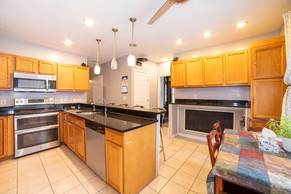 a kitchen with stainless steel appliances granite countertop a stove a sink and a refrigerator