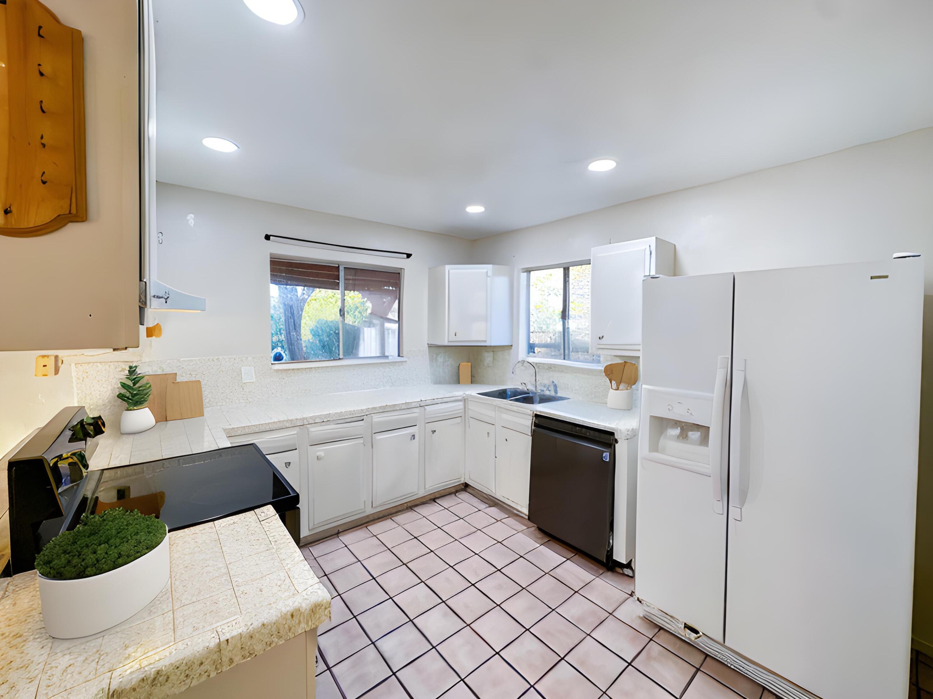 1228 West St George Avenue Ridgecrest, CA 93555 - Photo 11 of 30 a kitchen with a refrigerator and white cabinets
