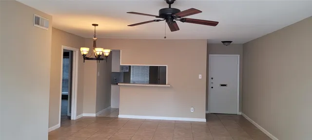 a view of a livingroom with a chandelier fan and refrigerator